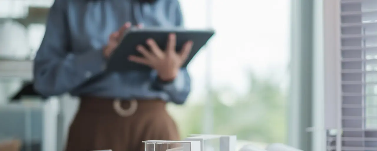 Person standing over table using tablet