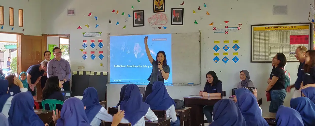 Young girls wearing blue hijabs learning in a classroom